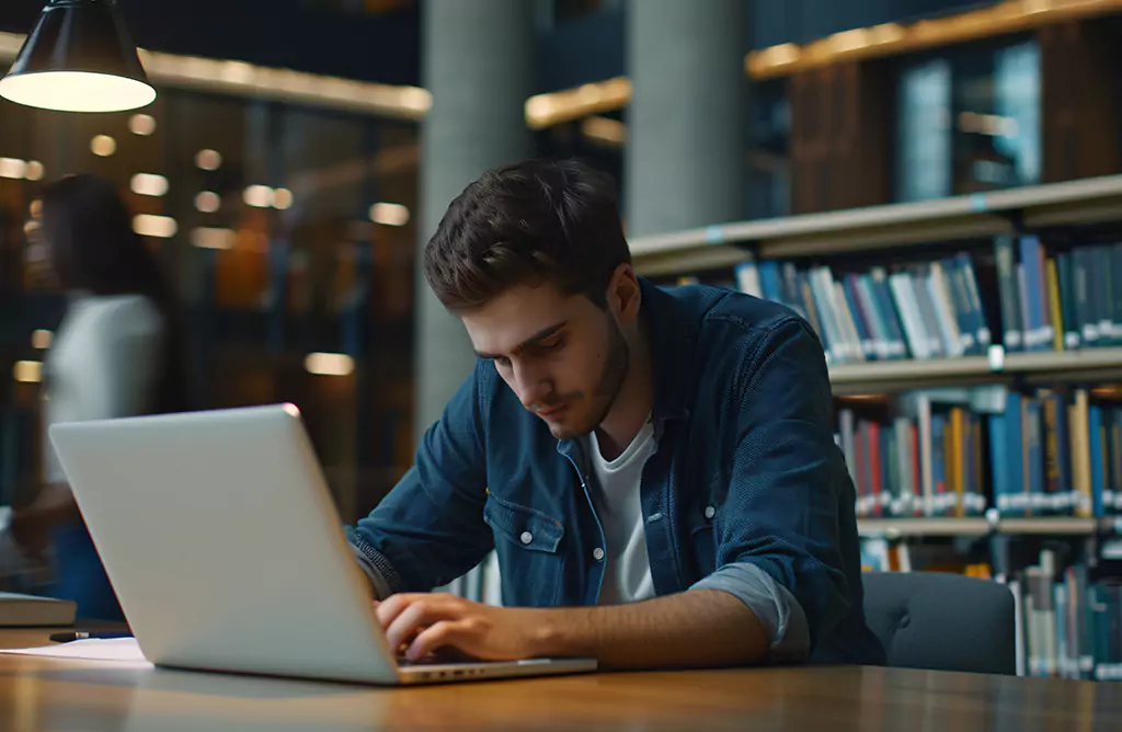 Student Working on a Laptop in a Library