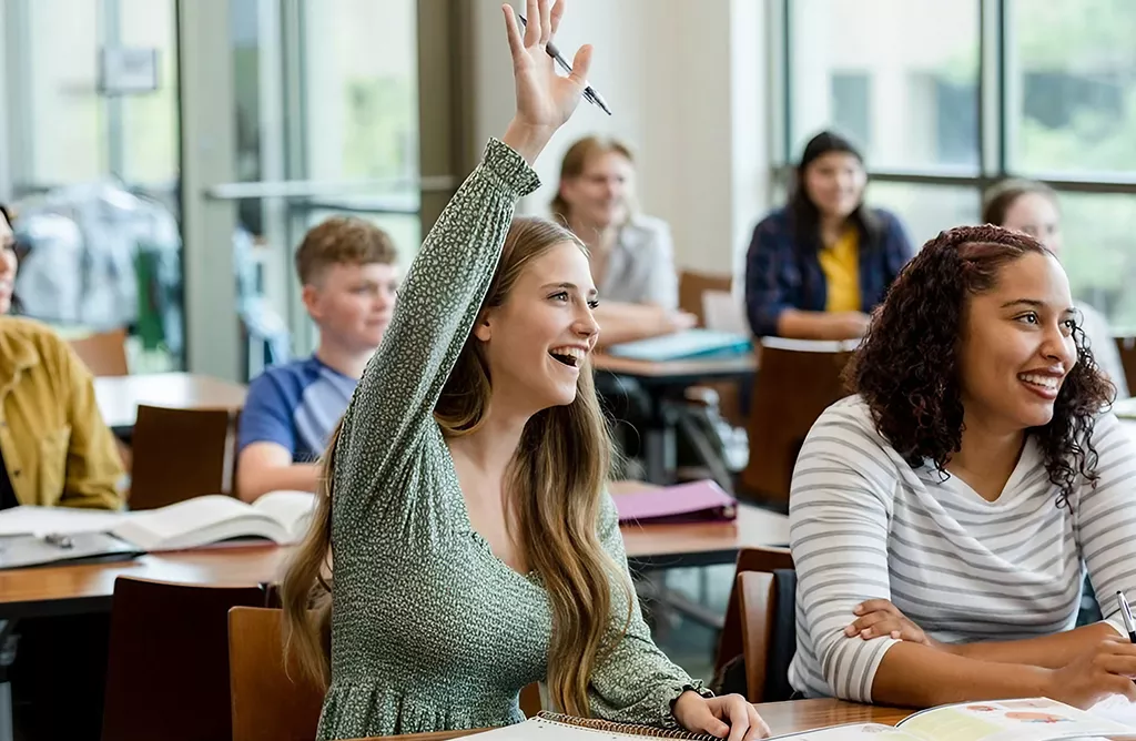 Student Raising Hand in a Bright Classroom During Lecture