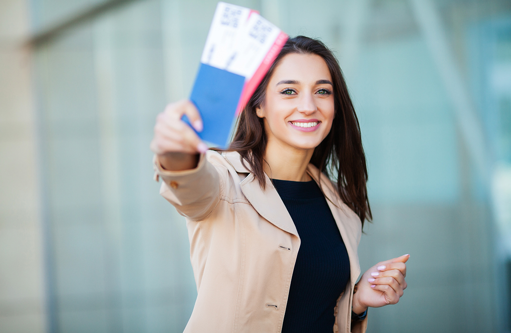 Woman Holding Passports and Smiling Outdoors
