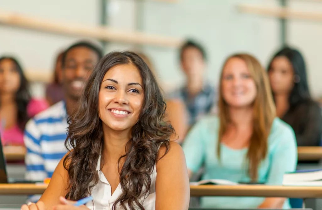 Smiling Student in a Classroom with Classmates Behind