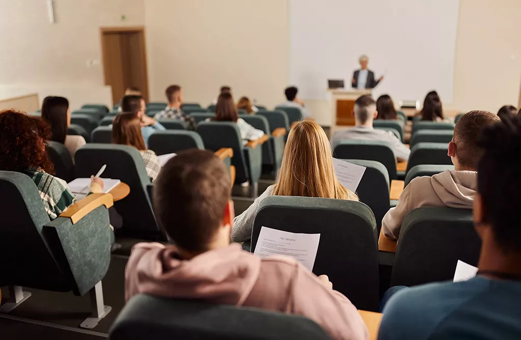 Students Attending a Lecture in a University Classroom with a Professor Teaching