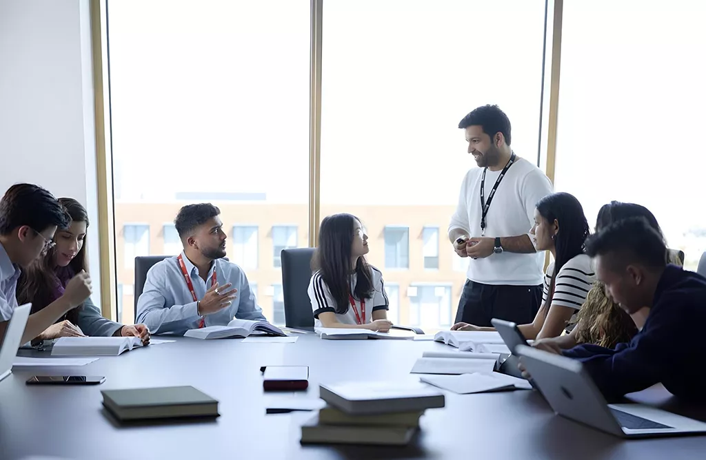 Students Discussing Coursework with Instructor in Classroom