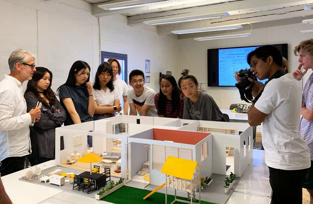 Students Observing a Scaled Architectural Model During a Design Class Workshop