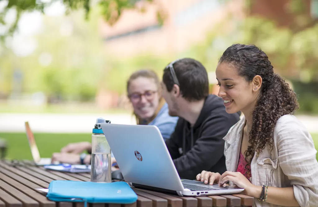 Students Studying on Laptops at an Outdoor Campus Table