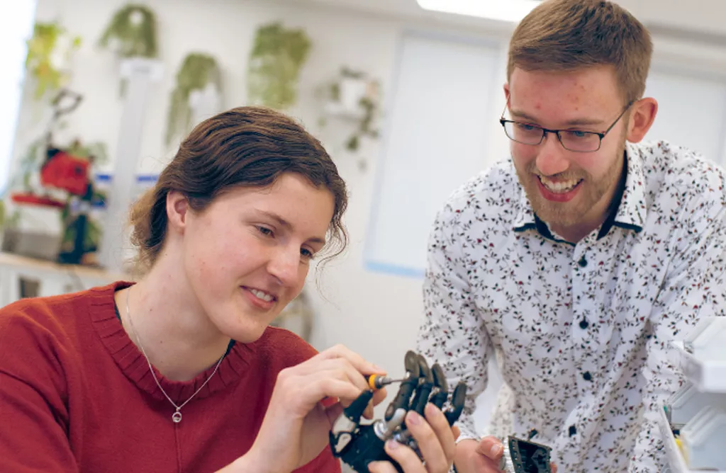 Two People Working on a Mechanical Device in a Lab