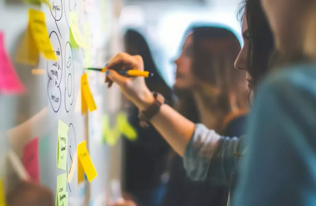 Students Planning Study Abroad Goals on Board with Notes and Strategy Discussion