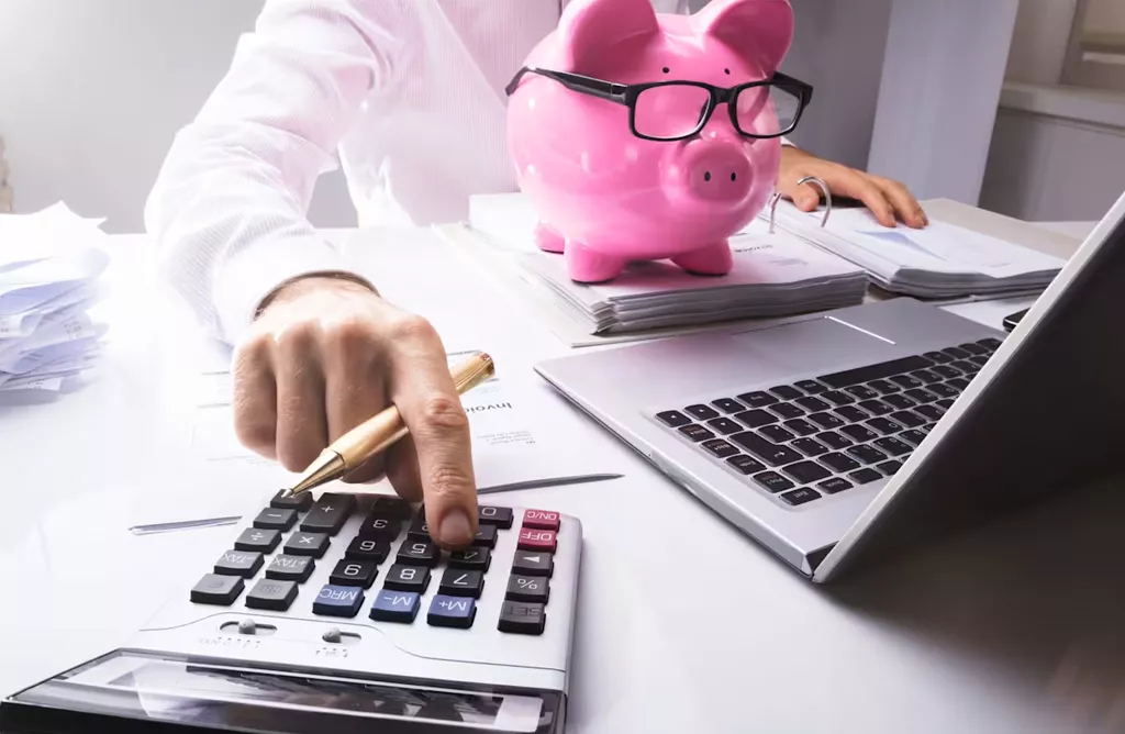 Student budgeting expenses with calculator and savings for studying in Finland