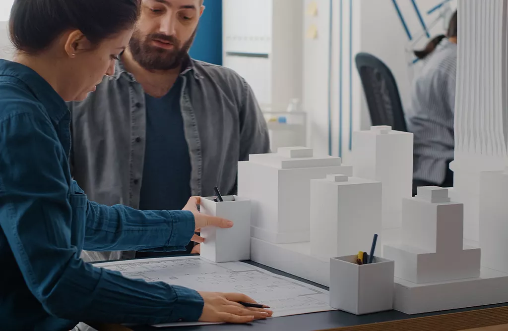 Architecture Students Reviewing Building Models and Design Plans in Italy