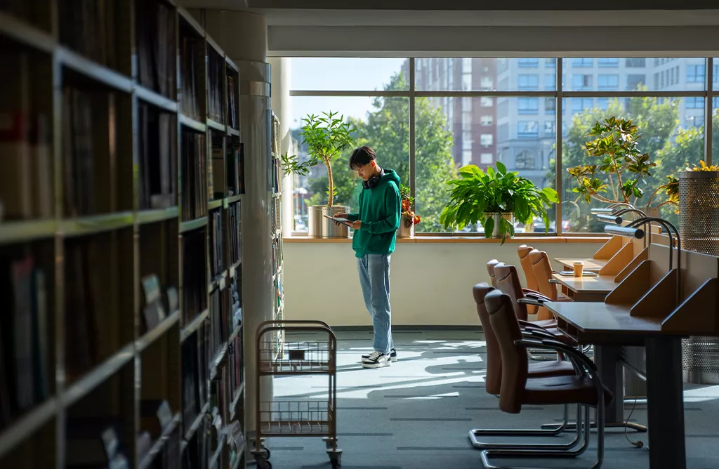 Student Exploring Academic Resources in a Finnish University Library